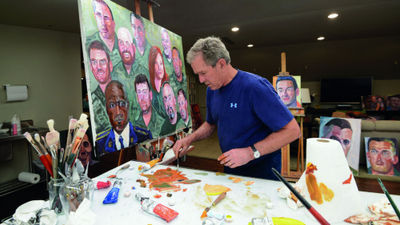 Former President George W. Bush working on one of his portraits of service members.