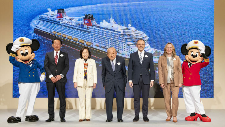 Executives from Disney and the Oriental Land Co. are flanked by Mickey and Minnie Mouse at an event to share details of their agreement to bring Disney sailings to Japan in 2029. Behind them is a rendering of the ship that will be used for those initial sailings.