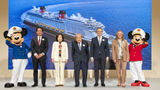 Executives from Disney and the Oriental Land Co. are flanked by Mickey and Minnie Mouse at an event to share details of their agreement to bring Disney sailings to Japan in 2029. Behind them is a rendering of the ship that will be used for those initial sailings.