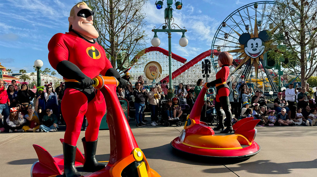 Mr. and Mrs. Incredible in hovercraft during the Better Together: A Pixar Pals Celebration parade.