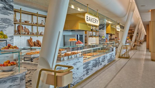 White marble in the Market and Bakery pay tribute to New York delis. The penny-round ceiling over the food counter is a hat-tip to the original JFK terminal, designed by architect Eero Saarinen.