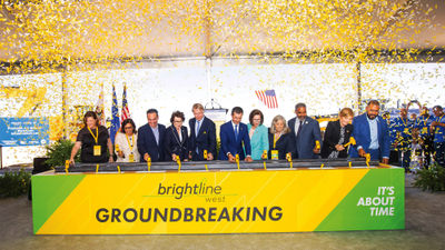 Officials hammer the first spike commemorating the groundbreaking for the Brightline West high-speed rail project.